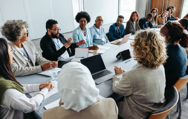 Une assemblée de partenaires diversifiée discute lors d'une réunion d'affaires.